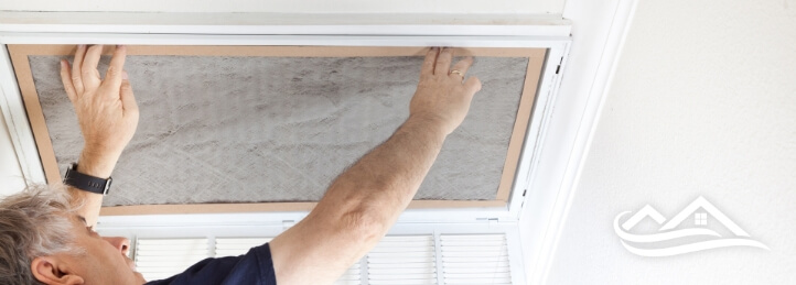 Man changing a filter on an IAQ system