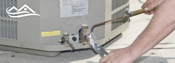 Technician working on an AC unit outside